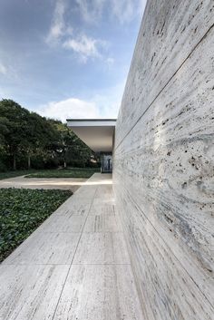 the exterior of a building with concrete walls and grass growing on the ground next to it