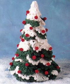 a crocheted christmas tree with red and white balls on it's top