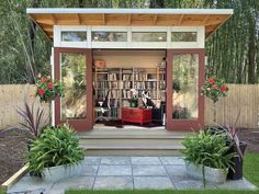 an outdoor library with potted plants and bookshelves on the front porch area