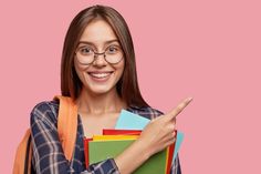 a woman with glasses pointing to the side and holding several folders in her hand