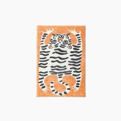 an orange rug with a tiger on it's face and two hands in the middle