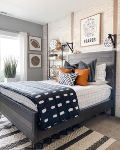 a bed sitting in a bedroom next to a window with lots of pillows on top of it