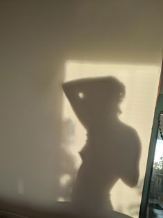 the shadow of a person in a hat on a window sill