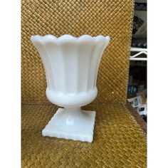 a white vase sitting on top of a table