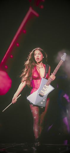 a woman in tights holding an electric guitar