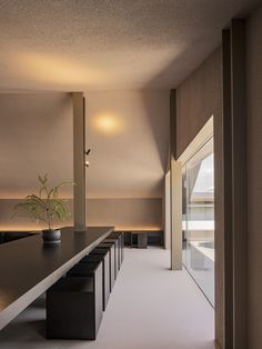 an empty room with benches and a potted plant on the table next to it