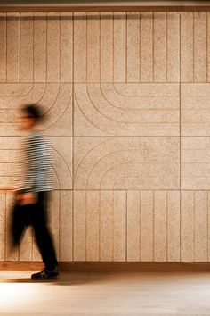 a blurry photo of a man walking past a wall