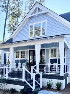 a blue house with white trim and black railings on the front porch is shown