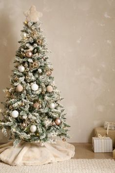 a white christmas tree with gold and silver ornaments