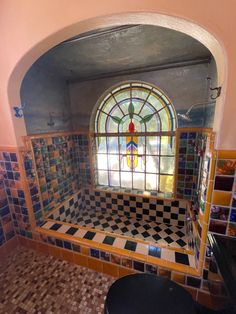 a bath room with a toilet and a stained glass window