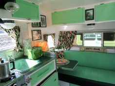 the interior of a camper with green and white decor on it's walls