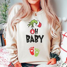 "🎄Celebrate the joy of pregnancy this holiday season with our \"A little Who is Due\" Christmas Sweatshirt! This cozy winter sweater is perfect for holiday gender reveals or as a thoughtful gift for expectant mothers at Christmas baby showers. Made with comfort in mind, it's a festive way to share your exciting news. Order now and make your holiday season extra special! 👕 PRODUCT INFO This unisex heavy blend crewneck sweatshirt and hoodie are pure comfort. These garments are made from polyester and cotton and run true to size with a loose fit. This combination helps designs come out looking fresh and beautiful. ✏️ DESIGN Designs are printed onto the shirt using Direct to Garment (DTG), which means the ink is laid directly into the fabric resulting in a bright, full-colored design. This h Pregnancy Christmas Sweater, Grinch Baby Announcement, Grinch Pregnancy Announcement, Pregnant Christmas Shirt, Baby On The Way Announcement, Holiday Gender Reveal, Christmas Maternity, Gender Reveal Gifts, Christmas Pregnancy Announcement