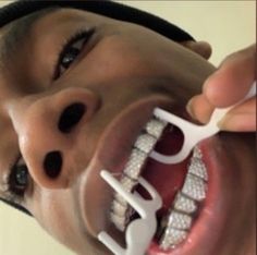 a young man is brushing his teeth with an electric toothbrush in front of him