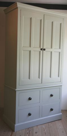 a white armoire with two drawers and three doors