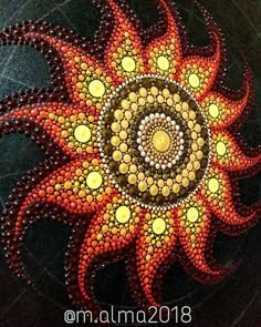 an artistic painting made out of beads and stones with the shape of a sunflower