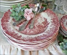 a stack of plates topped with flowers and silverware