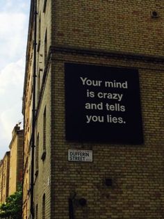 a sign on the side of a building that says your mind is crazy and tells you lies