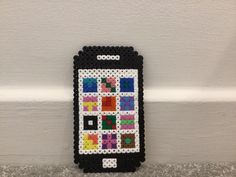 a cell phone made out of legos on the wall next to a white wall