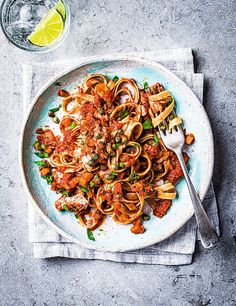 a white plate topped with pasta and meat