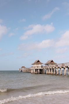 a pier on the ocean with people walking along it