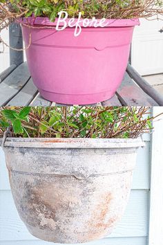 a pink flower pot sitting on top of a wooden table next to a planter