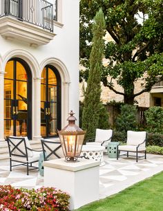 an outdoor patio with chairs and a lamp