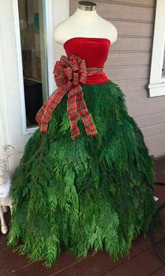 a dress made out of grass with a red top and bow on the front yard