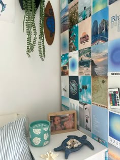 a white table topped with pictures next to a wall covered in magnets and photos