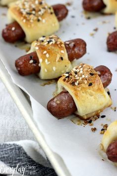 hot dogs wrapped in bread and topped with sesame seeds