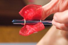 a person holding a pen with a red flower on it