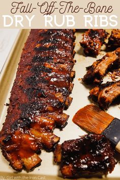 bbq ribs and barbecue sauce on a tray with a spatula next to them