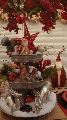 a three tiered tray with christmas decorations on it