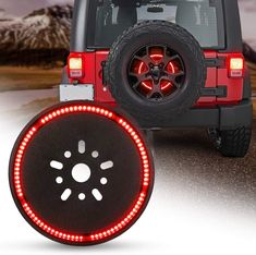 the tire cover has red lights on it and is in front of a jeep with snow covered mountains in the background