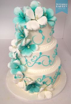 a wedding cake with blue and white flowers on it