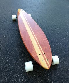 a skateboard is laying on the ground with white wheels and woodgrain covering it