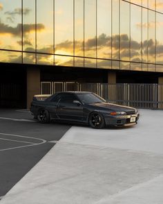 a black car parked in front of a tall building