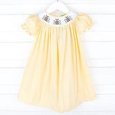 Bzzz, bzzz! Get ready for buzzing adventures with our Bee Smocked Yellow Gingham Bishop Dress. Designed in cheerful yellow with polka dots, this dress features adorable smocked bees and bishop-style sleeves, making it an irresistibly cute choice. Bee Kids Dress, Patriotic Swimwear, Smocked Bishop Dress, Kids Fall Outfits, Yellow Gingham, Angel Sleeves, Street Kids, Bubble Dress, Gingham Fabric