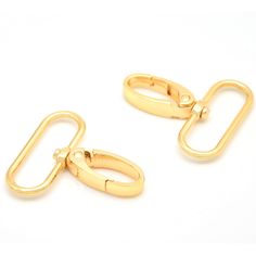 two gold - plated paper clips are shown on a white surface, one is open and the other is closed