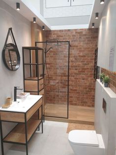 a bathroom with a toilet, sink and shower stall in the middle of the room