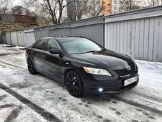 a black car is parked in the snow