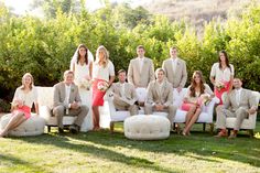 a group of people sitting on top of white couches in front of some trees