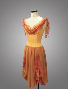 a mannequin wearing an orange and yellow dress with ruffles on it