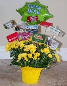 a bouquet of yellow flowers in a yellow vase with balloons and thank you signs on the wall