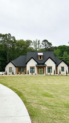 a large white house sitting on top of a lush green field