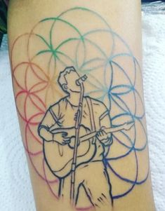 a person with a guitar on their leg and colored circles around them behind the man