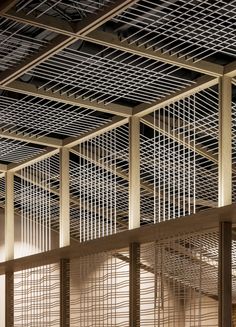 the inside of a building with metal screens on the ceiling and wood beams above it