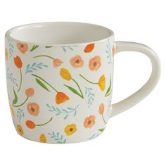 a white coffee cup with orange and yellow flowers on it