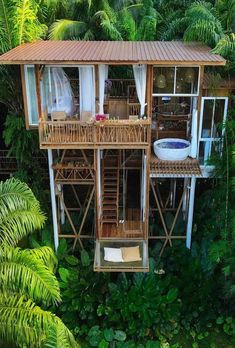 an aerial view of a tree house in the middle of some tropical trees and greenery