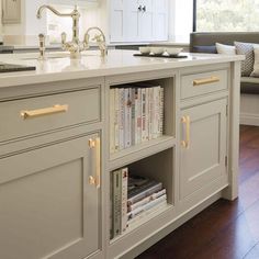 a kitchen island with bookshelves and cabinets in it