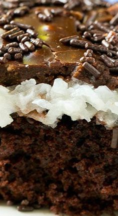 a close up of a piece of cake on a plate with chocolate frosting and sprinkles